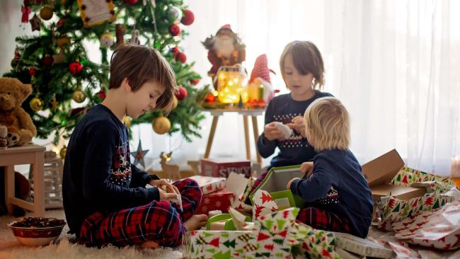 Happy children, opening presents on christmas day