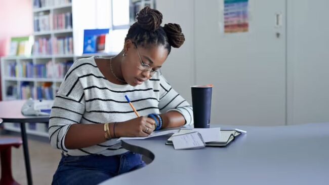 female-student-writing-on-paper-library-desk-study-1296×728-header-1024×575 girl studying for school