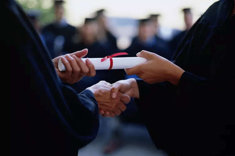 school diploma being handed off