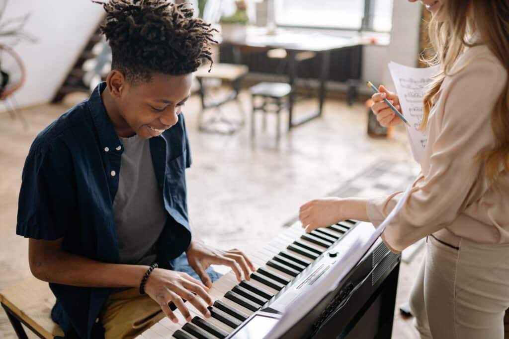 A teenager enjoying a piano lesson