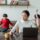 mother working on a laptop at home while her children play