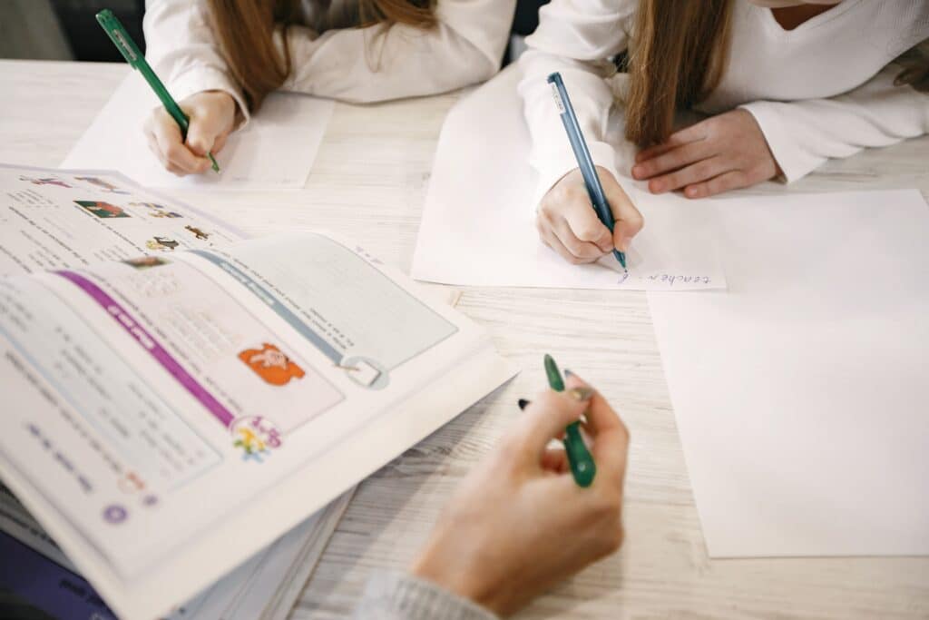 adult teaching children with book open